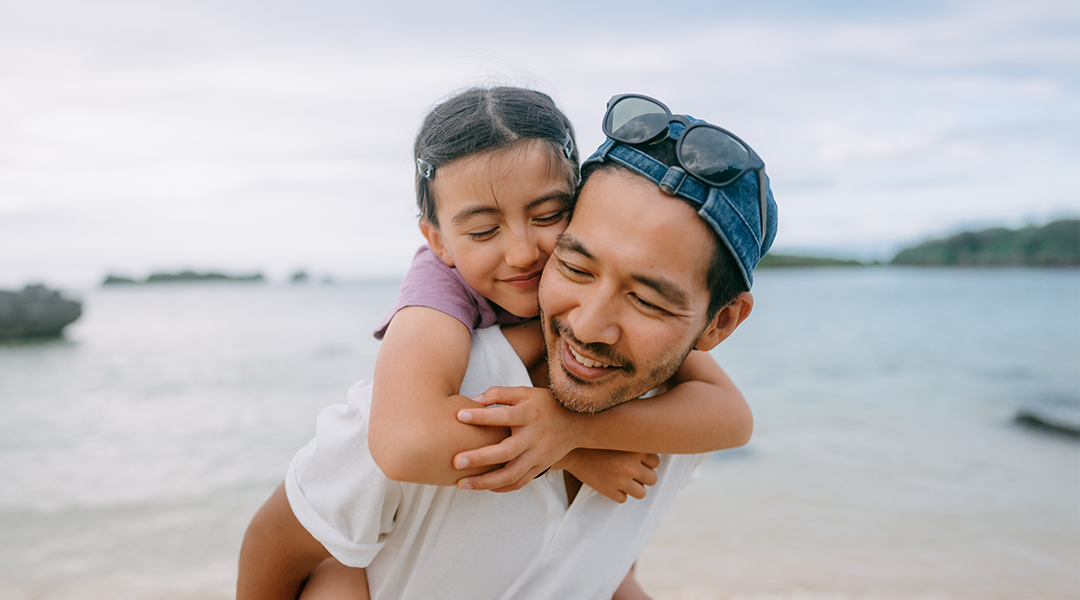 Smiling girl on the back of dads shoulders