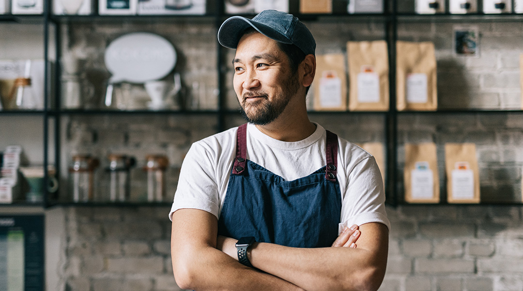 A man of asian descent looking to his right smiling at something