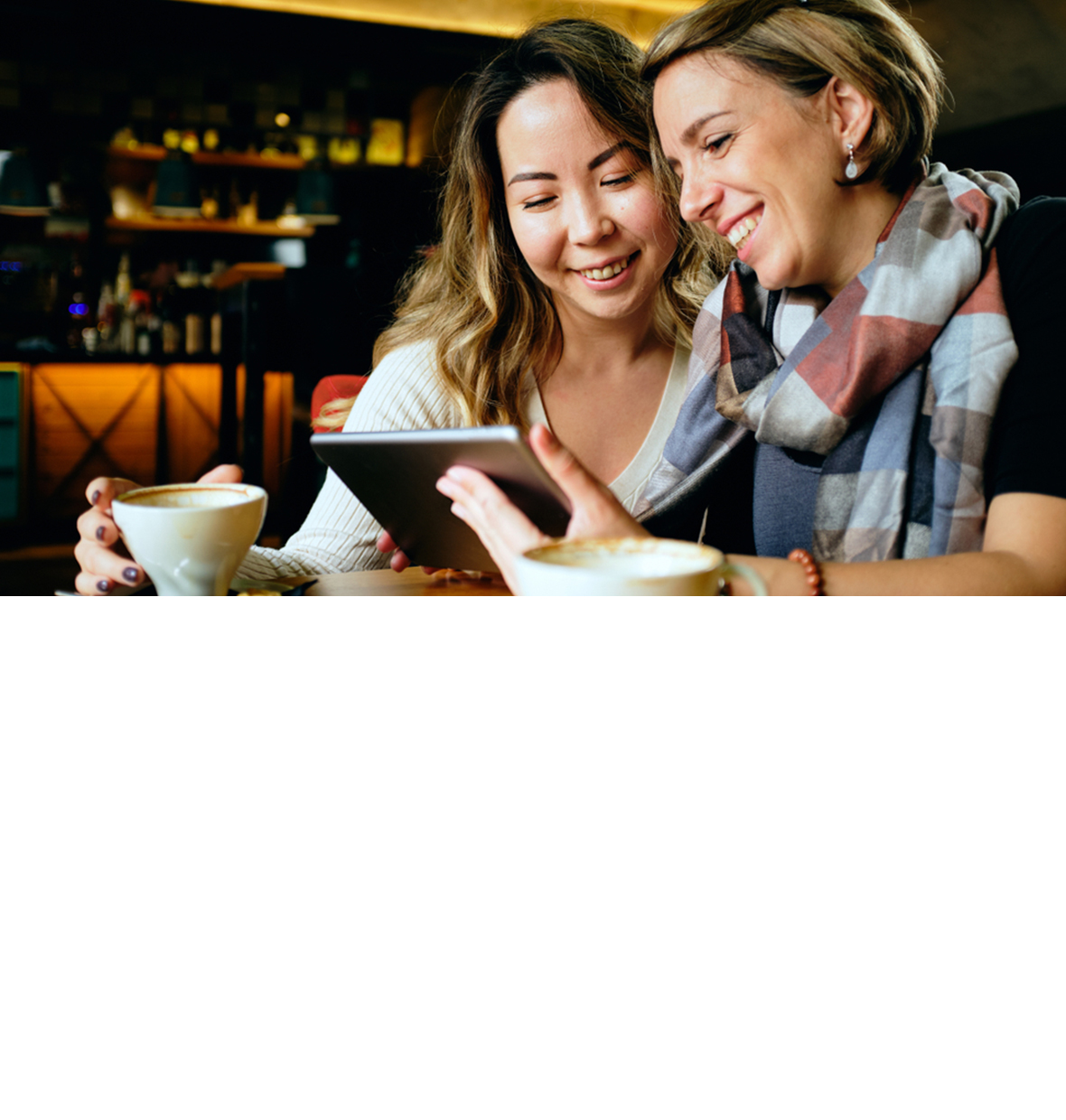 two women looking down at the table smiling